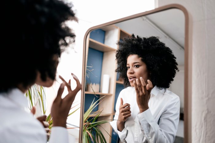 woman applying cream to face