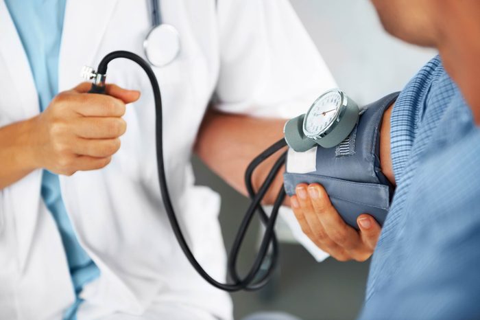 doctor checking man's blood pressure