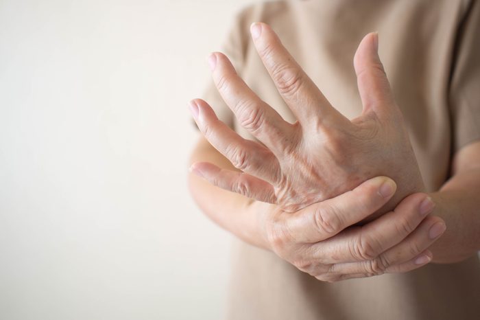 Elderly woman suffering from pain, numbness or weakness in hands. Causes of hurt include osteoarthritis, rheumatoid arthritis, gout, peripheral neuropathy, lupus or Raynaud’s phenomenon. Health care.