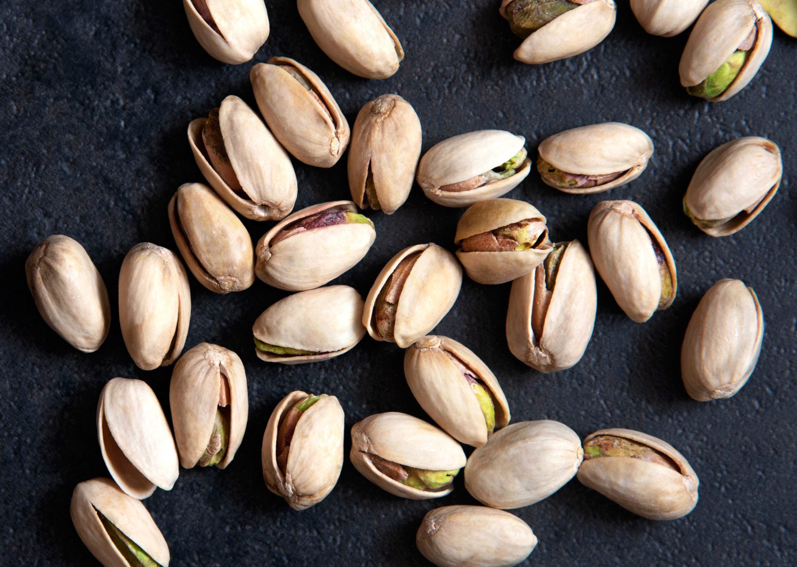 Roasted pistachios nuts on dark background
